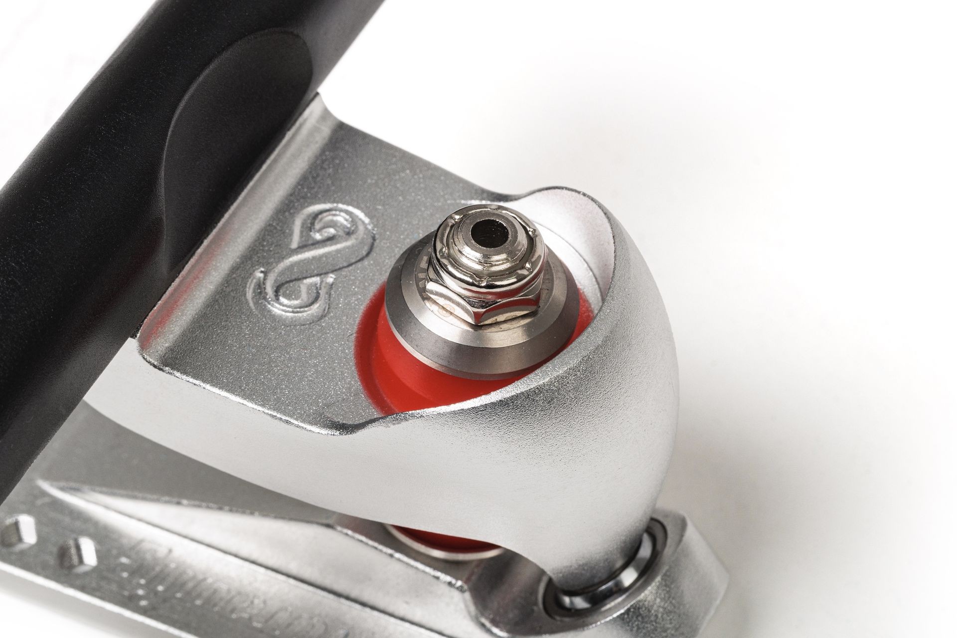 Close-up of a skateboard truck with red bushing and metallic components on a white background.